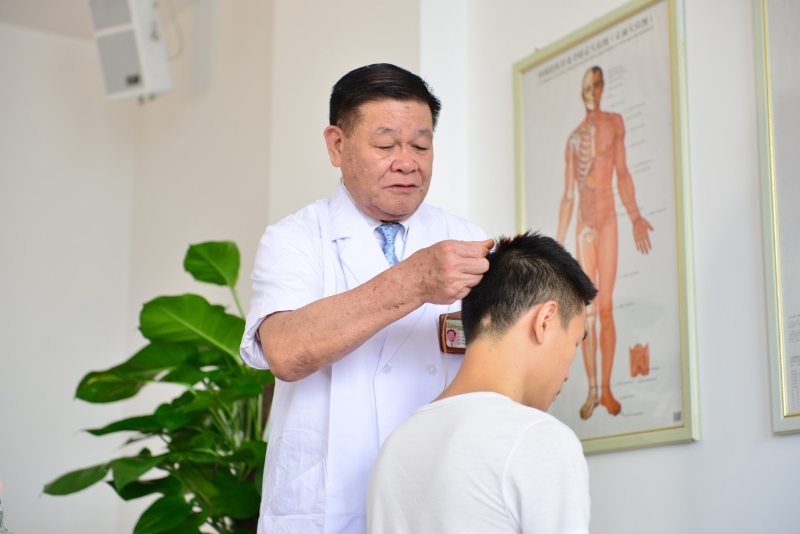 国医大师黄瑾明为患者进行壮医药线点灸疗法治疗。bat365在线官网平台供图